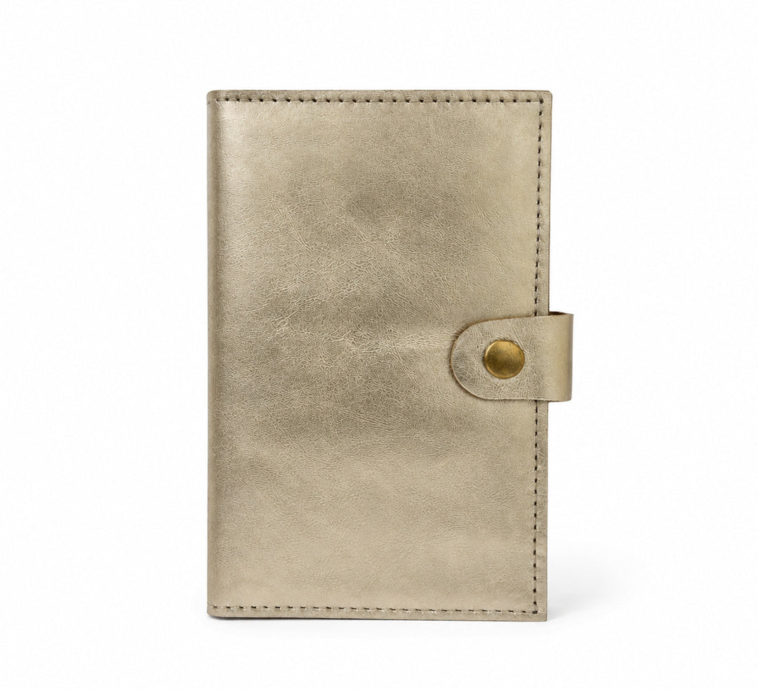 Interior de cartera MANIKĀ de piel vacuna metalizada dorada, con ranuras para tarjetas y la frase "la gratitud es la semilla de la abundancia" grabada